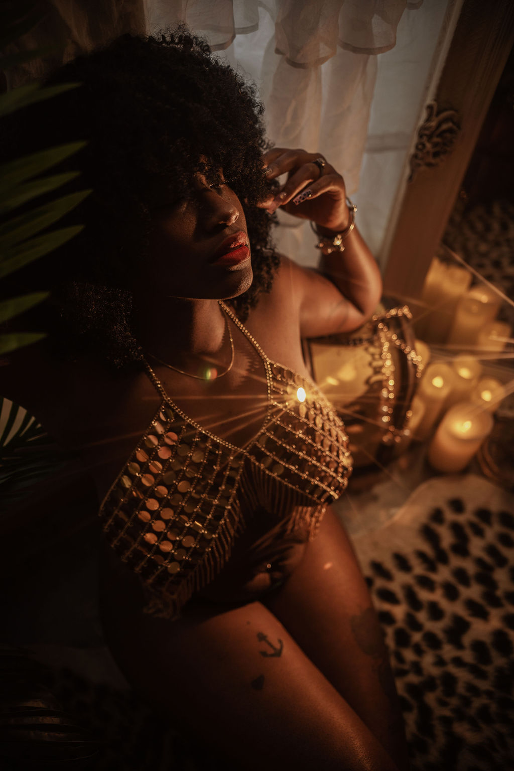 black woman in gold lingerie with her hand in her afro by best dallas hair salons